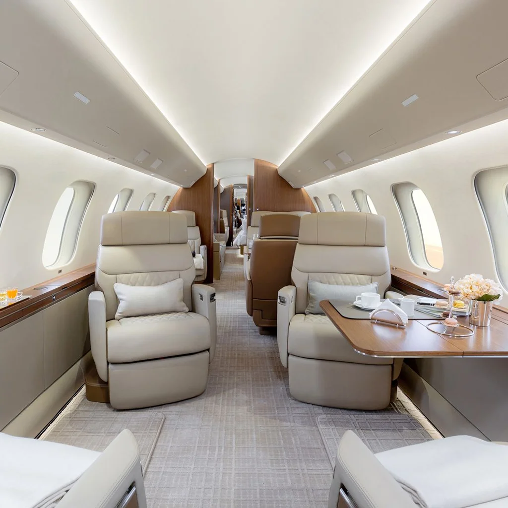 Interior view of a luxury private jet cabin with premium leather seating and executive workspace setup